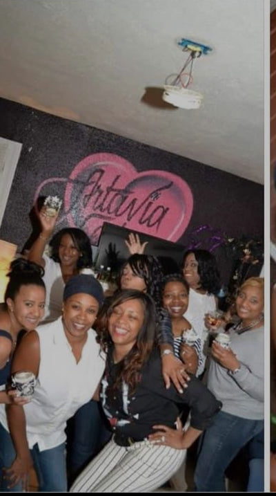 Group of friends celebrating at Friendsgiving Candle Making Party with joyful smiles and drinks in hand.